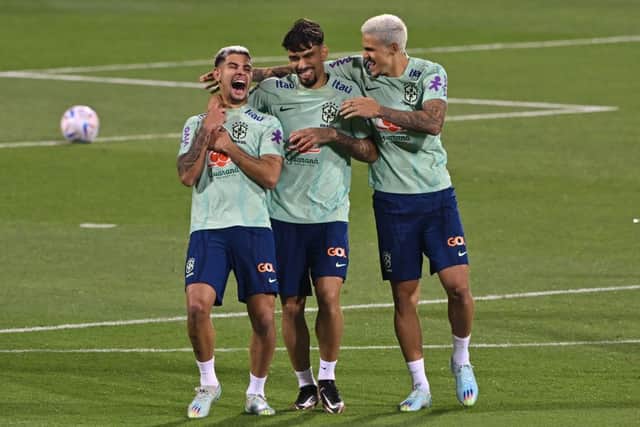 Brazil's midfielders Bruno Guimaraes (L) and Lucas Paqueta and forward Pedro laugh during a training session at the Al Arabi SC Stadium in Doha on November 20, 2022, just moments before the kick-off of the Qatar 2022 World Cup football tournament. (Photo by NELSON ALMEIDA / AFP)