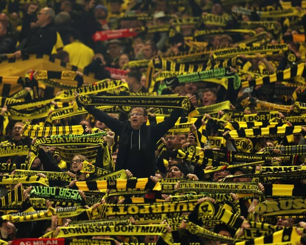 Borussia Dortmund fans show their support whilst holding up scarves prior to the Bundesliga match between Borussia Dortmund and SV Werder Bremen at Signal Iduna Park on October 20, 2023 in Dortmund, Germany. 