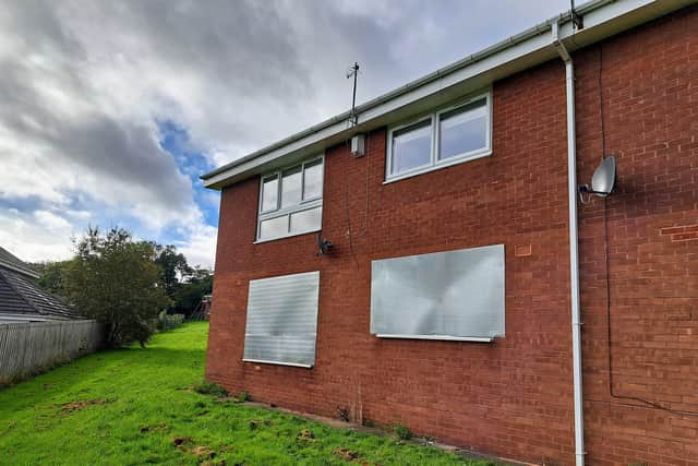 Windows of the house are now boarded up.