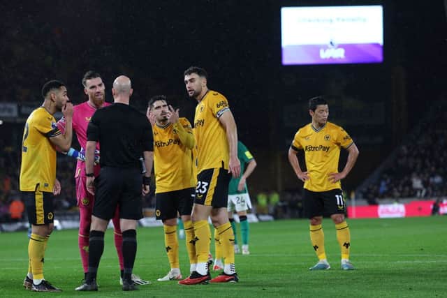 Wolves players appeal to English referee Anthony Taylor as the VAR (Video Assistant Referee) analyses a possible penalty offence from Wolverhampton Wanderers' South Korean striker #11 Hwang Hee-chan (R) during the English Premier League football match between Wolverhampton Wanderers and Newcastle United at the Molineux stadium in Wolverhampton, central England on October 28, 2023. (Photo by Adrian DENNIS / AFP) 