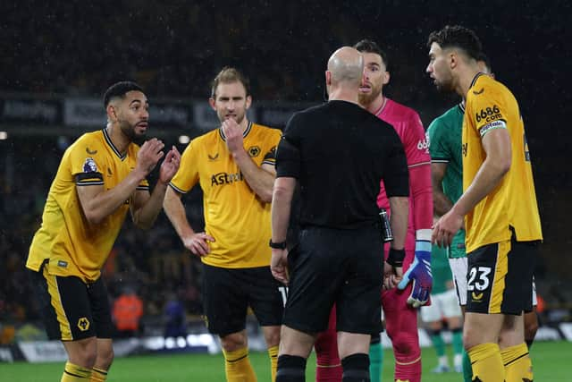 Wolves players appeal to English referee Anthony Taylor as the VAR (Video Assistant Referee) analyses a possible penalty offence during the English Premier League football match between Wolverhampton Wanderers and Newcastle United at the Molineux stadium in Wolverhampton, central England on October 28, 2023. (Photo by Adrian DENNIS / AFP)