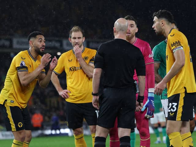 Wolves players appeal to English referee Anthony Taylor as the VAR (Video Assistant Referee) analyses a possible penalty offence during the English Premier League football match between Wolverhampton Wanderers and Newcastle United at the Molineux stadium in Wolverhampton, central England on October 28, 2023. (Photo by Adrian DENNIS / AFP)