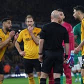 Wolves players appeal to English referee Anthony Taylor as the VAR (Video Assistant Referee) analyses a possible penalty offence during the English Premier League football match between Wolverhampton Wanderers and Newcastle United at the Molineux stadium in Wolverhampton, central England on October 28, 2023. (Photo by Adrian DENNIS / AFP)