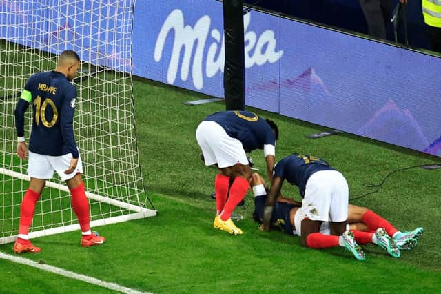 Paris Saint-Germain midfielder Warren Zaire-Emery down injured whilst playing for France. (Photo by VALERY HACHE/AFP via Getty Images)