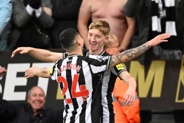Anthony Gordon of Newcastle United celebrates with teammate Miguel Almiron after scoring the team's fourth goal during the Premier League match between Newcastle United and Chelsea FC at St. James Park on November 25, 2023 in Newcastle upon Tyne, England. (Photo by Stu Forster/Getty Images)