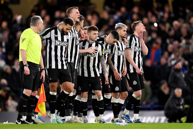 Kieran Trippier of Newcastle United is consoled by team mates of Newcastle United after missing their sides penalty during a penalty shoot out in the Carabao Cup Quarter Final match between Chelsea and Newcastle United at Stamford Bridge on December 19, 2023 in London, England.