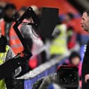 Chris Kavanagh checks VAR ahead of showing a red card to Everton striker Dominic Calvert-Lewin. (Photo by Mike Hewitt/Getty Images)