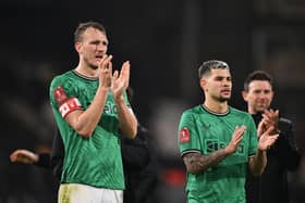 Dan Burn and Bruno Guimaraes of Newcastle United show appreciation to the fans following the Emirates FA Cup Fourth Round match between Fulham and Newcastle United at Craven Cottage on January 27, 2024 in London, England.