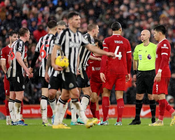 Referee Anthony Taylor interacts with Dan Burn of Newcastle United and Virgil van Dijk of Liverpool. (Photo by Jan Kruger/Getty Images)