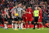 Referee Anthony Taylor interacts with Dan Burn of Newcastle United and Virgil van Dijk of Liverpool. (Photo by Jan Kruger/Getty Images)