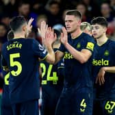 Fabian Schar of Newcastle United celebrates scoring his team's second goal with teammate Sven Botman during the Premier League match between Nottingham Forest and Newcastle United at City Ground on February 10, 2024 in Nottingham, England.