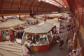 A view of the interior of the Grainger Market Newcastle upon Tyne taken in 1977. The photograph has been taken from one of the balconies inside the hall and is looking down onto the stalls and shops. The hall has an iron and glass roof. The buildings is decorated with flags and bunting for the Silver Jubilee of Queen Elizabeth II.