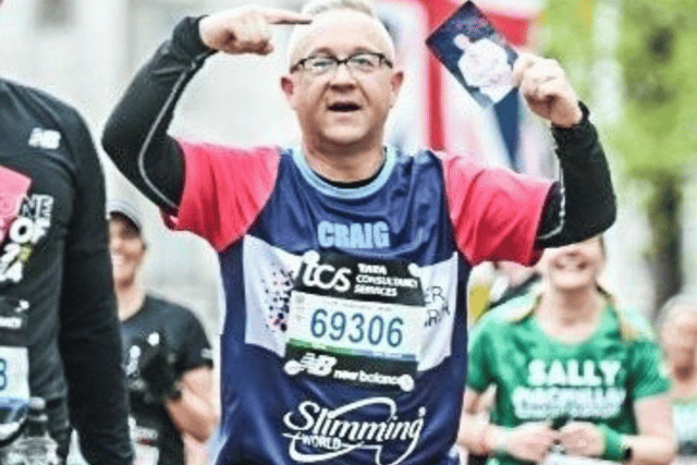 Craig Falcus ran the London Marathon as part of a 17-strong Slimming World team. He held a photo of his mam, who had cancer, as he crossed the finish line. Photo: Other 3rd Party.