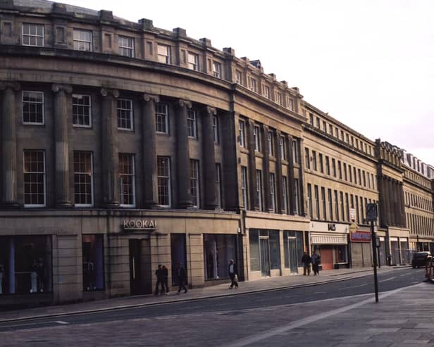 A view of left-hand side of Grainger Street Newcastle upon Tyne taken in 2002. The photograph is looking along Grainger Street from Market Street. In the foreground to the left is Market Street. 'Kookai' is on the ground floor of the building on the corner of Grainger Street and Market Street the next two shops are empty then 'Ball's' and 'McGurk Sports'. 