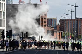 Smoke billows as police officers face off protesters in Liverpool on August 3, 2024 during the 'Enough is Enough' demonstration held in reaction to the fatal stabbings in Southport on July 29.