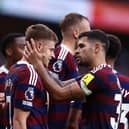 Harvey Barnes of Newcastle United celebrates scoring his team's second goal with teammates during the Premier League match between Wolverhampton Wanderers FC and Newcastle United FC at Molineux on September 15, 2024 in Wolverhampton, England.