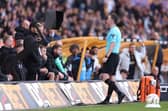 Chris Kavanagh checks the Video Assistant Referee screen to review Manchester City's second goal, scored by John Stones.