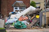 Horrified residents are demanding action after their neighbours turned their home into a makeshift TIP with tonnes of rubbish dumped on the driveway.  