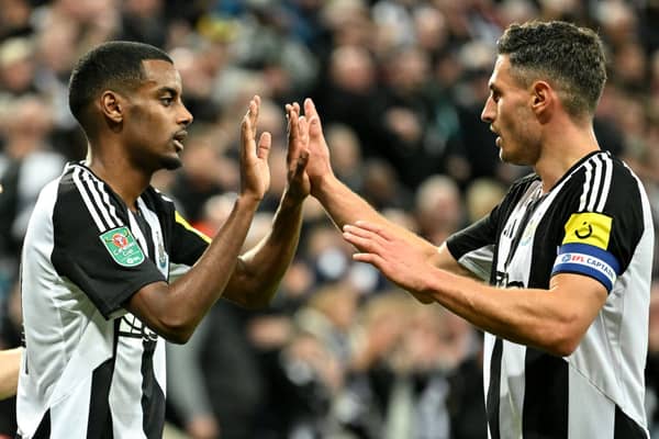 Newcastle United's Swedish striker #14 Alexander Isak (L) celebrates scoring the team's first goal during the English League Cup round of 16 football match between Newcastle United and Chelsea. (Photo by ANDY BUCHANAN/AFP via Getty Images)