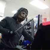 Moment armed robber in Halloween mask raids shop till.