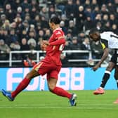 Alexander Isak of Newcastle United scores his team's first goal whilst under pressure from Virgil van Dijk of Liverpool during the Premier League match between Newcastle United FC and Liverpool FC at St James' Park on December 04, 2024 in Newcastle upon Tyne, England. (Photo by Justin Setterfield/Getty Images)