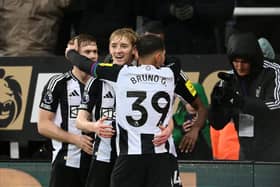 Anthony Gordon of Newcastle United celebrates scoring his team's second goal with teammate Bruno Guimaraes during the Premier League match between Newcastle United FC and Liverpool FC at St James' Park on December 04, 2024 in Newcastle upon Tyne, England. (Photo by Stu Forster/Getty Images)