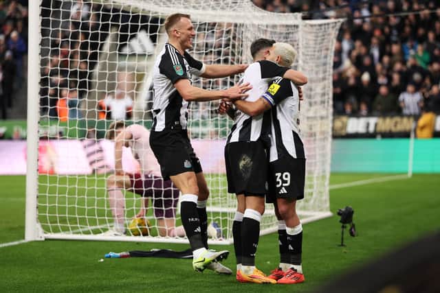 Fabian Scher of Newcastle United celebrates scoring his team's third goal with teammates Dan Burn and Bruno Guimaraes. (Photo by Carl Recine/Getty Images)