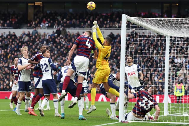 Tottenham Hotspur's English goalkeeper #40 Brandon Austin punches the ball clear under pressure from Newcastle United's Dutch defender #04 Sven Botman during the English Premier League football match between Tottenham Hotspur and Newcastle United at the Tottenham Hotspur Stadium in London, on January 4, 2025.
