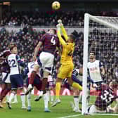 Tottenham Hotspur's English goalkeeper #40 Brandon Austin punches the ball clear under pressure from Newcastle United's Dutch defender #04 Sven Botman during the English Premier League football match between Tottenham Hotspur and Newcastle United at the Tottenham Hotspur Stadium in London, on January 4, 2025.