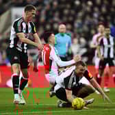 Gabriel Martinelli of Arsenal is challenged by Sven Botman (L) and Dan Burn of Newcastle United (R) during the Carabao Cup Semi Final Second Leg match between Newcastle United and Arsenal at St James' Park on February 05, 2025 in Newcastle upon Tyne, England. (Photo by Stu Forster/Getty Images)