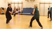 Two people, training with lightsabers