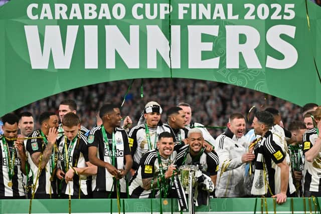 Newcastle United's Brazilian midfielder #39 Bruno Guimaraes (C-L) and Newcastle United's Brazilian midfielder #07 Joelinton (C-R) celebrate with the League Cup trophy after winning the English League Cup final football match between Liverpool and Newcastle United at Wembley Stadium, north-west London on March 16, 2025. Newcastle United wins English League Cup 2 -1 against Liverpool. (Photo by Glyn KIRK).