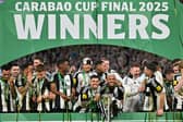 Newcastle United's Brazilian midfielder #39 Bruno Guimaraes (C-L) and Newcastle United's Brazilian midfielder #07 Joelinton (C-R) celebrate with the League Cup trophy after winning the English League Cup final football match between Liverpool and Newcastle United at Wembley Stadium, north-west London on March 16, 2025. Newcastle United wins English League Cup 2 -1 against Liverpool. (Photo by Glyn KIRK).