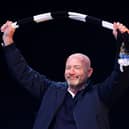 Former Newcastle United player Alan Shearer acknowledges the fans as he holds up a Newcastle United scarf while on stage during the Newcastle United trophy parade and celebration on March 29, 2025 in Newcastle upon Tyne, England. Newcastle United defeated Liverpool in the Carabao Cup Final to end their seventy-year domestic trophy drought. (Photo by Ed Sykes/Getty Images)
