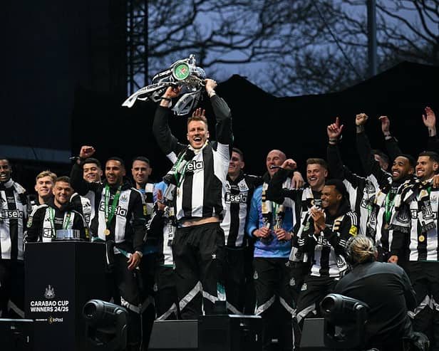 Newcastle United's English defender #33 Dan Burn celebrates with the League Cup trophy on stage at the Town Moor in Newcastle upon Tyne, in north-east England, on March 29, 2025, during a celebration and presentation with fans after Newcastle United won the English League Cup, their first domestic trophy for 70 years. (Photo by Oli SCARFF / AFP) (Photo by OLI SCARFF/AFP via Getty Images)          