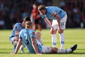 Kevin De Bruyne and Phil Foden (obscured) of Manchester City interact team mate Erling Haaland after he sustains an injury during the Emirates FA Cup Quarter Final match between AFC Bournemouth and Manchester City at Vitality Stadium on March 30, 2025 in Bournemouth, England. 