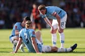 Kevin De Bruyne and Phil Foden (obscured) of Manchester City interact team mate Erling Haaland after he sustains an injury during the Emirates FA Cup Quarter Final match between AFC Bournemouth and Manchester City at Vitality Stadium on March 30, 2025 in Bournemouth, England. 