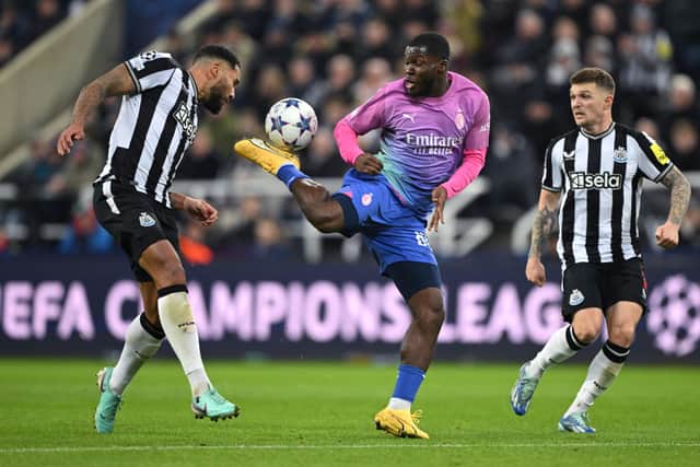 AC Milan player Yunus Musah is challenged by Jamaal Lascelles (l) as Kieran Trippier looks on during the UEFA Champions League match between Newcastle United FC and AC Milan at St. James Park on December 13, 2023 in Newcastle upon Tyne, England. (Photo by Stu Forster/Getty Images)