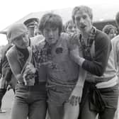 Newcastle United striker Peter Beardsley is congratulated by Newcastle Fans on the pitch after a 2-2 draw against Huddersfield Town which seals promotion back to the First Division for United at Leeds Road on May 7, 1984  in Huddersfield, England. (Photo by Danny Brannigan/Hulton Archive)