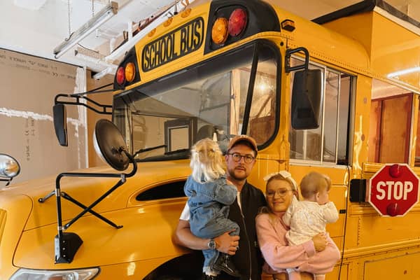 Lotti Harrison and Ty Burns with their American school bus that they are travelling around Europe in with their toddlers