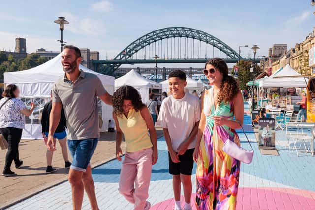 A family visit a Sunday market by the river Tyne in Newcastle upon Tyne