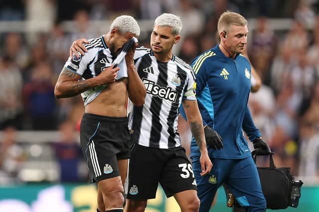 Joelinton of Newcastle United is consoled by teammate Bruno Guimaraes as he leaves the field after suffering an injury during the Premier League match between Newcastle United and Liverpool at St James' Park on August 25, 2025 in Newcastle upon Tyne, England.