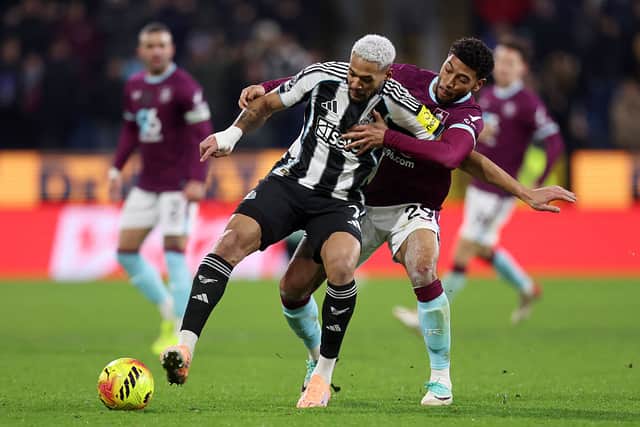 Josh Laurent of Burnley battles for possession with Joelinton of Newcastle United during the Premier League match between Burnley and Newcastle United at Turf Moor on December 30, 2025 in Burnley, England.