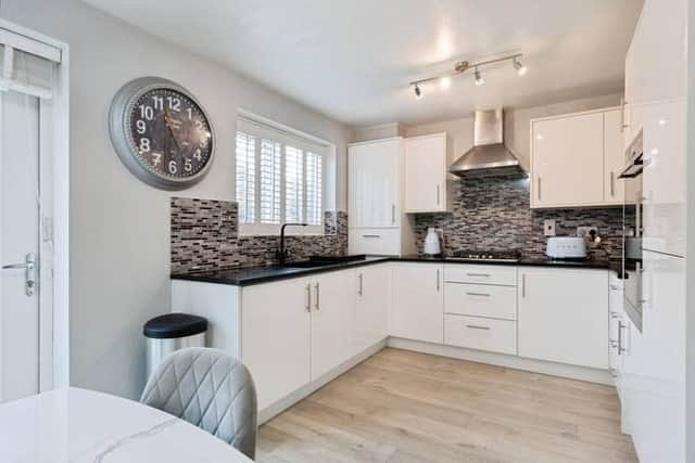 The contemporary kitchen diner features high-gloss units and opens directly onto the rear garden