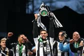 Newcastle United's Brazilian midfielder #39 Bruno Guimaraes celebrates with the League Cup trophy on stage at the Town Moor in Newcastle upon Tyne, in north-east England, on March 29, 2025, during a celebration and presentation with fans after Newcastle United won the English League Cup, their first domestic trophy for 70 years. (Photo by Oli SCARFF / AFP) (Photo by OLI SCARFF/AFP via Getty Images)          