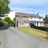 The semi-detached home has a generous front garden and large driveway, providing off-street parking for multiple vehicles.
