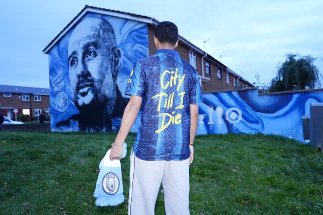 A Manchester City fan outside a Pep Guardiola mural ahead of the game (Nick Potts/PA)