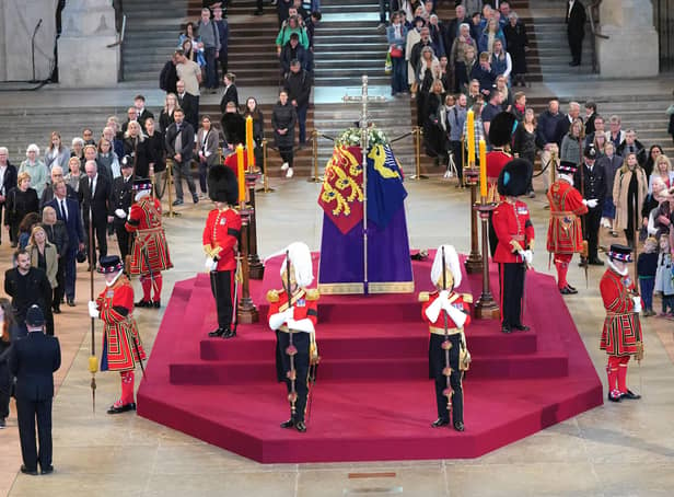 <p>Members of the public file past the coffin of Queen Elizabeth II, draped in the Royal Standard with the Imperial State Crown and the Sovereign's orb and sceptre, lying in state on the catafalque in Westminster Hall, at the Palace of Westminster, London, ahead of her funeral on Monday. Picture: Yui Mok/PA Wire</p>