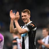 Dan Burn applauds Newcastle United fans at St James' Park.