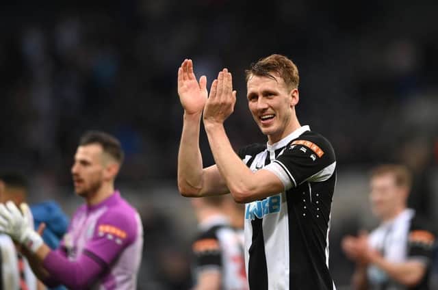 Dan Burn applauds Newcastle United fans at St James' Park.